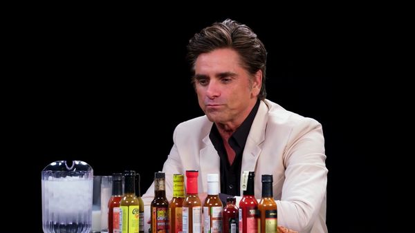 Hot Ones - John Stamos Falls Out of His Chair While Eating Spicy Wings