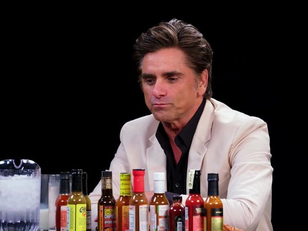 Hot Ones - John Stamos Falls Out of His Chair While Eating Spicy Wings